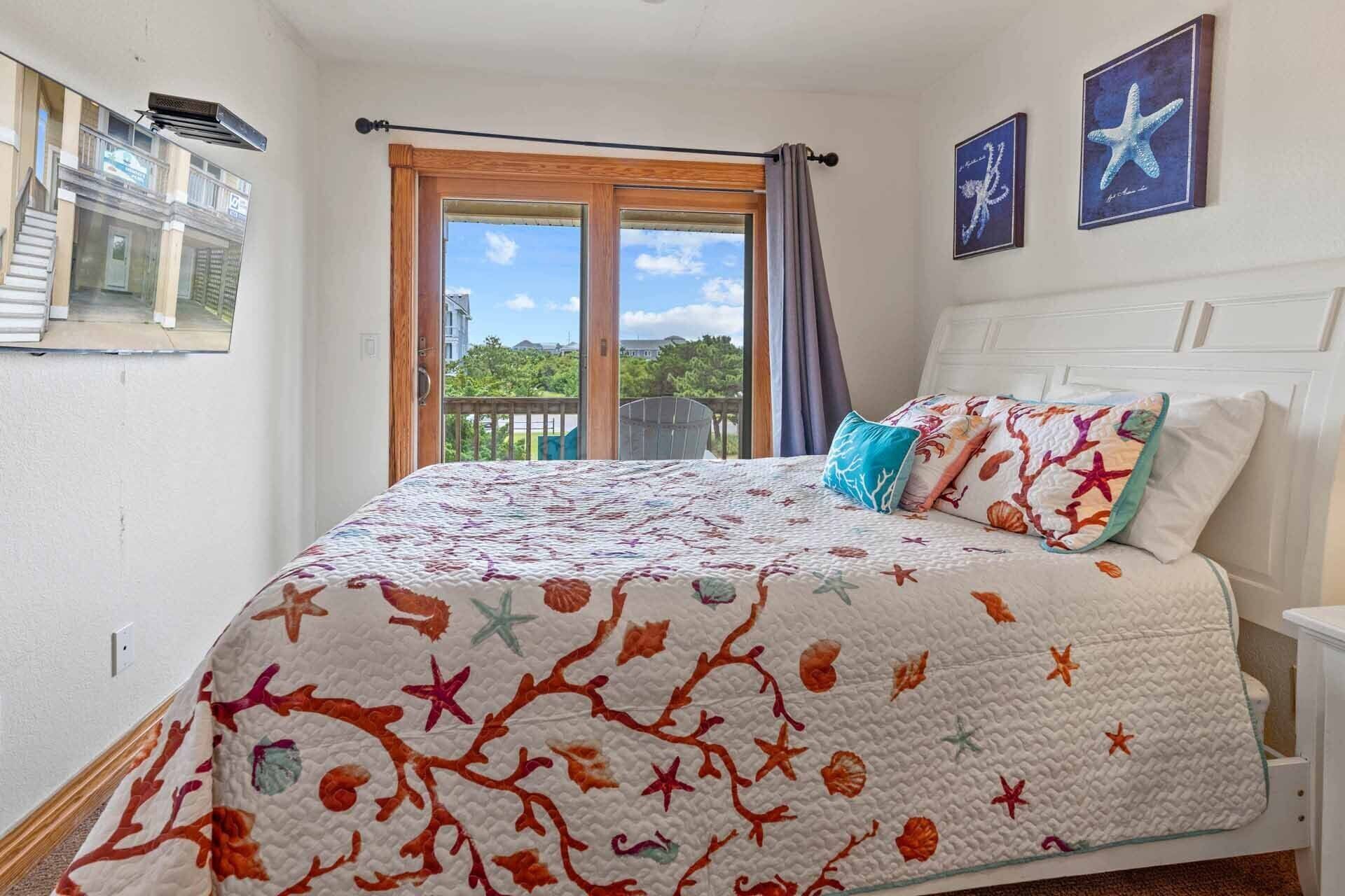 A bedroom with a large bed, a view of the outside, and a balcony.