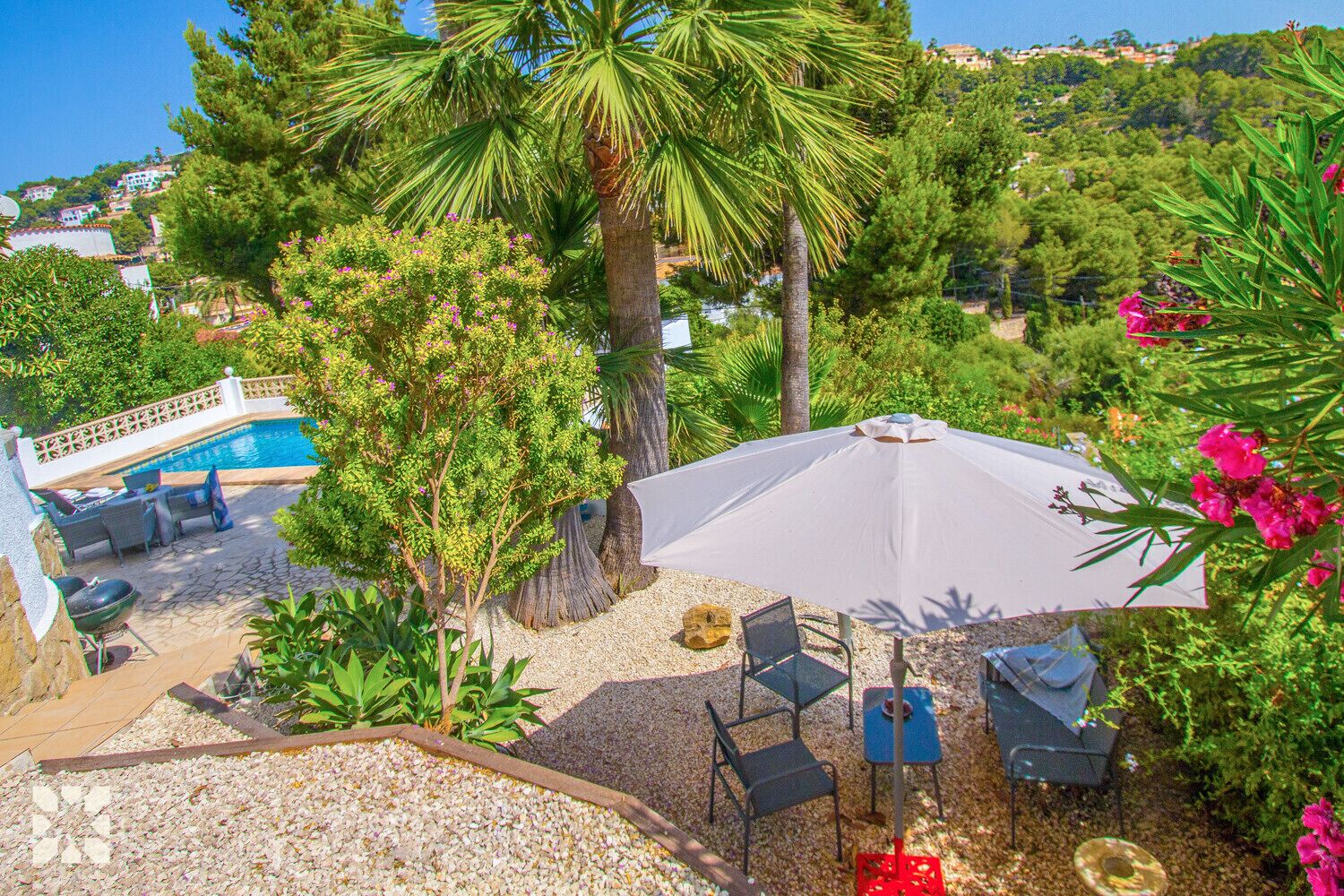 A pool area with outdoor seating and a large umbrella.