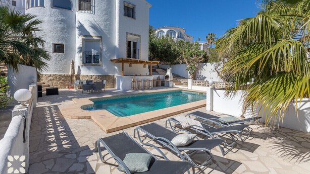 A poolside area with a pool, lounge chairs, and a bar area. - Villa GOOD VIBES by Abahana Villas (Benissa)