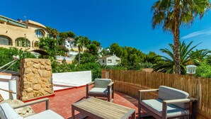A rooftop terrace with outdoor furniture, a stone wall, and a view of surrounding buildings. - Villa CASA PIPA by Abahana Villas (Benissa)