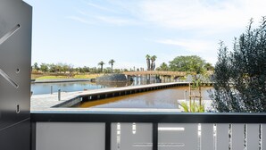 Une vue d’un élément décoratif aquatique avec un pont, entouré d’arbres et sous un ciel dégagé.