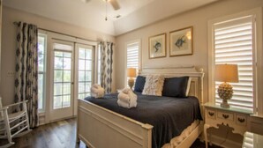A bedroom with a bed, a ceiling fan, a nightstand, and a window with blinds. - 87 Ocean Creek - Canal w/Shared Dock (Fripp Island)