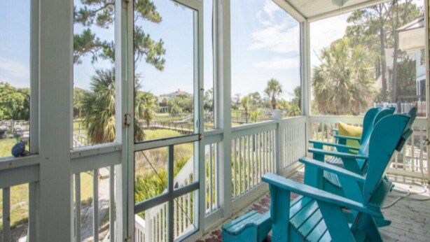 A covered porch with a view of a landscaped area and a pool. - 87 Ocean Creek - Canal w/Shared Dock (Fripp Island)