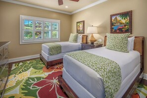 Une chambre d’hôtel avec deux lits, une fenêtre avec des stores, un tableau, une lampe et un tapis coloré.