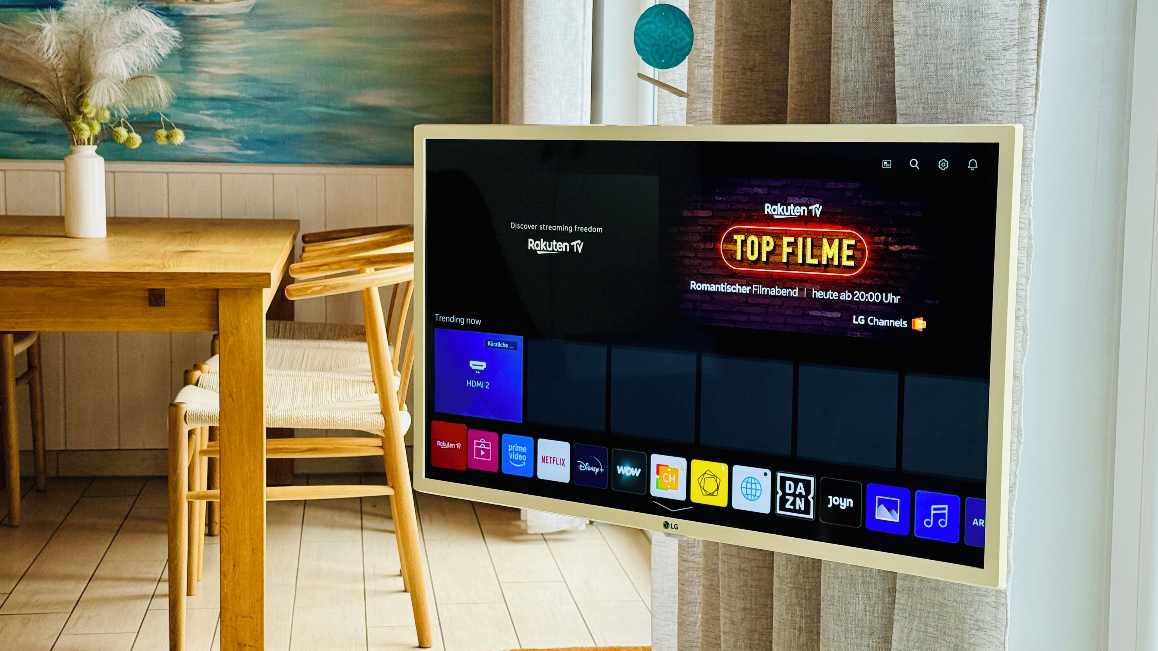 A flat-screen TV displaying a streaming service interface with a prominent 'TOP FILME' section.