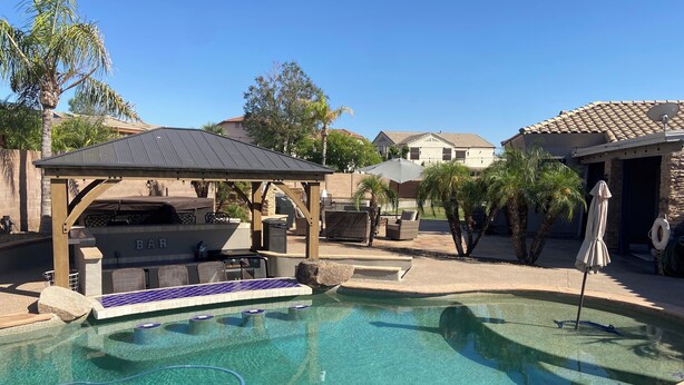 A backyard with a swimming pool, a barbecue area, and a covered seating area. - Great Vacation Home, Swim up Bar, Outdoor Living, New Pickleball Court (Phoenix)