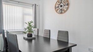 A conference room with a table, chairs, a clock, and a potted plant. - 3-beds, Sleeps 6 Walking Distance to Castle & Town (Abergele)