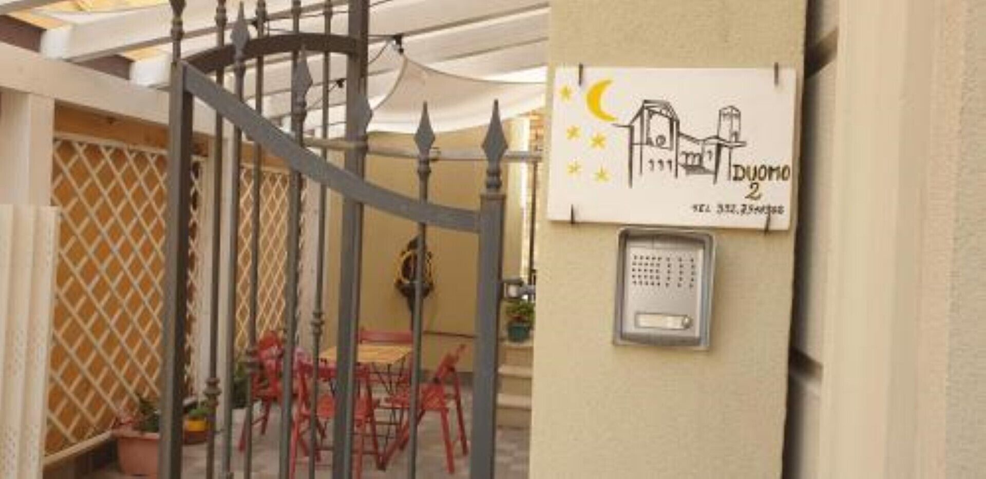 Ingresso recintato con tastierino di sicurezza e un cartello raffigurante una casa.