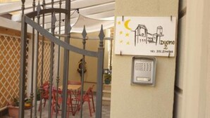 Ingresso recintato con tastierino di sicurezza e un cartello raffigurante una casa.