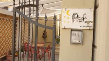 Ingresso recintato con tastierino di sicurezza e un cartello raffigurante una casa.