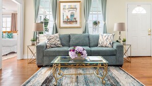 A living room with a sofa, a glass coffee table with a vase, and a door marked "EXIT". - Where Tranquility Blooms | Blossoms on Cannon (Charleston)