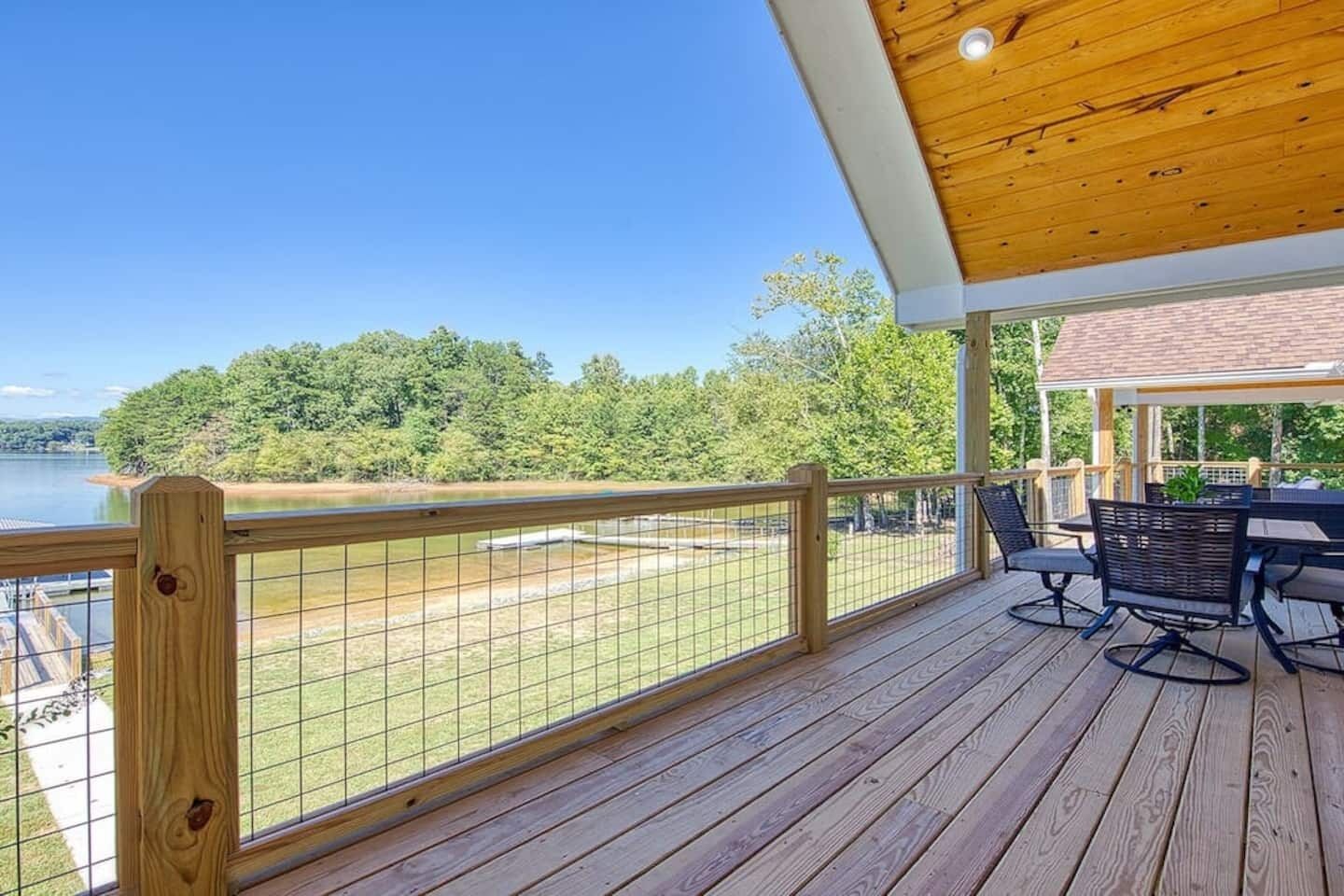Una terraza de madera con vista a un lago y árboles.