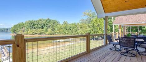 Una terraza de madera con vista a un lago y árboles.