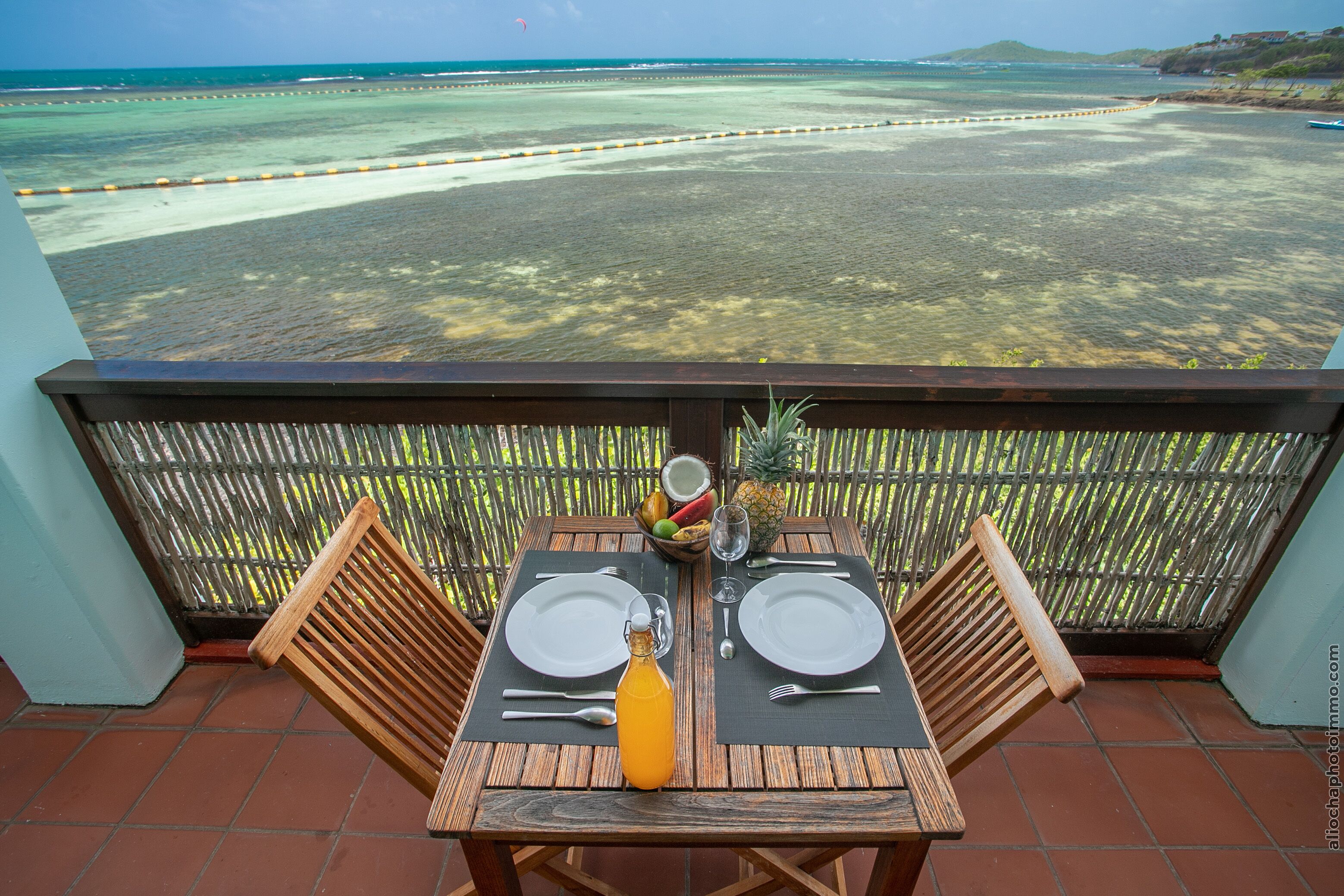 A table set for two with a view of the beach and ocean.