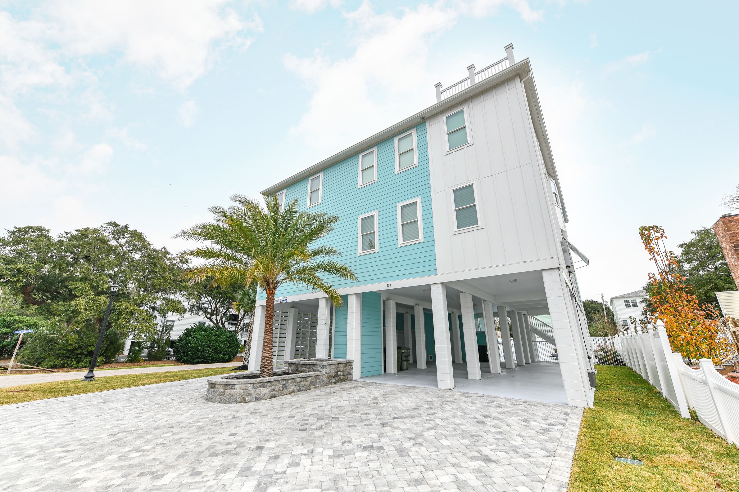A two-story building with a light blue and white exterior, a covered entrance area, and a paved walkway.