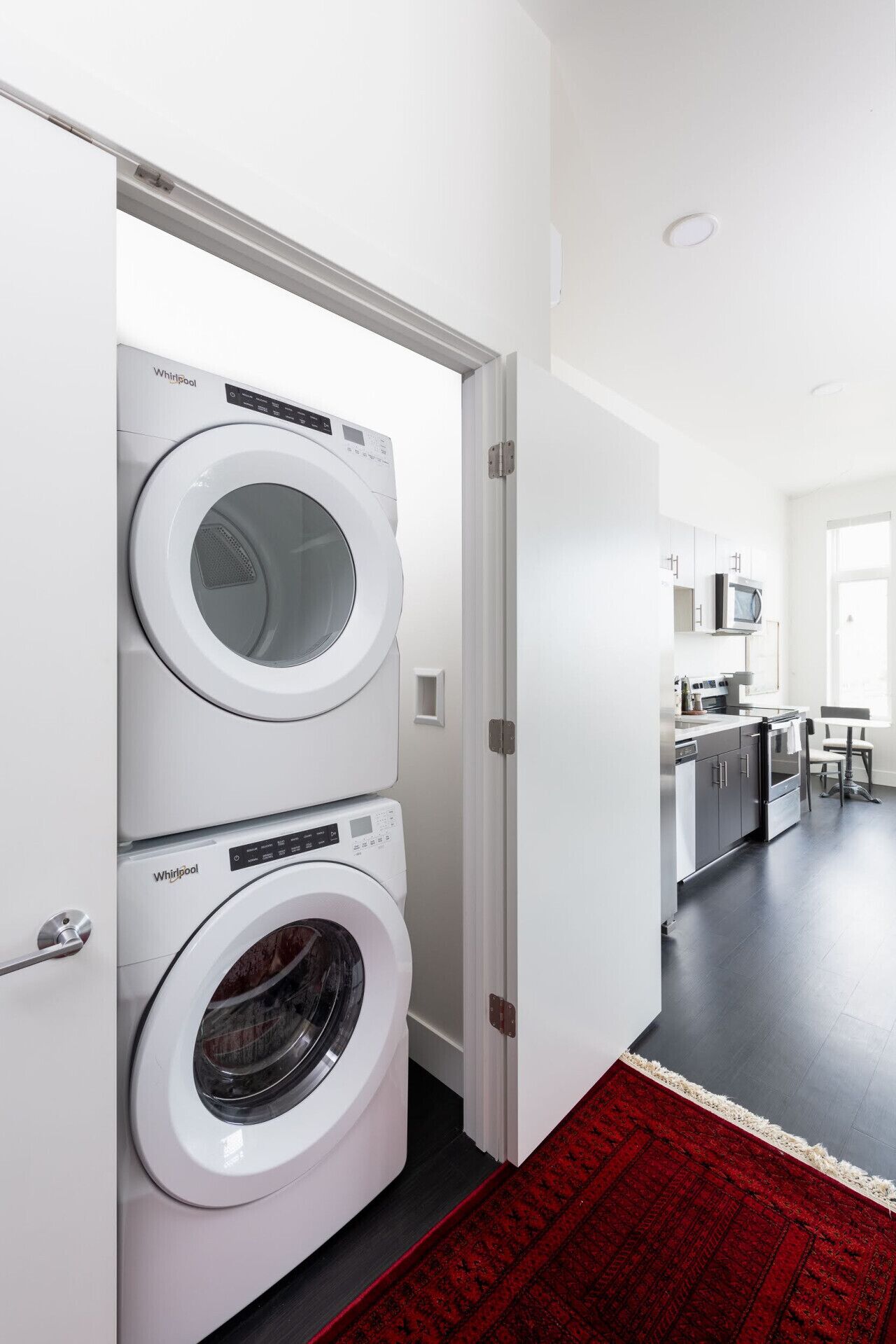 A laundry room with two stacked front-loading washers and dryers.