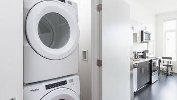 A laundry room with two stacked front-loading washers and dryers.