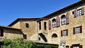 Un edificio de piedra con ventanas arqueadas y tejado de tejas.