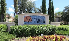 Welcome to Solterra Resort, surrounded by lush greenery and tall trees.