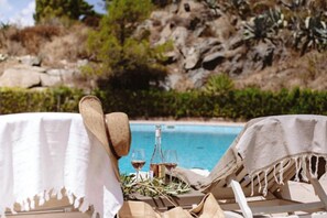 A poolside setting with lounge chairs and a table, a bottle, and glasses of wine. - Family 36 - Cap Sud Vacances, La Garde-Freinet (La Garde-Freinet)