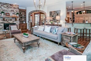 A spacious living room with a stone fireplace, a sofa set, and a coffee table.
