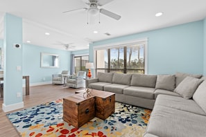 A living room with a gray sectional sofa, a wooden coffee table, and a colorful rug. - "Pipers Perch" - Book Fall Break with Golf Cart! (Miramar Beach)