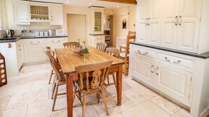 Una cocina con armarios de madera, una mesa de comedor y sillas.