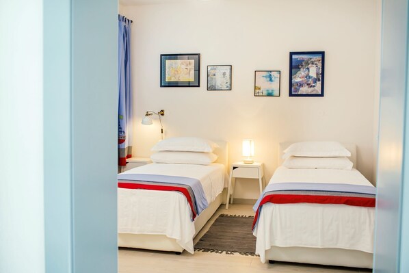A bedroom with two beds, a small rug, and three framed artworks on the wall. - Luxury Home with Swimming Pool, Professional Tennis Court and Boccia Alley (Donji Proložac)