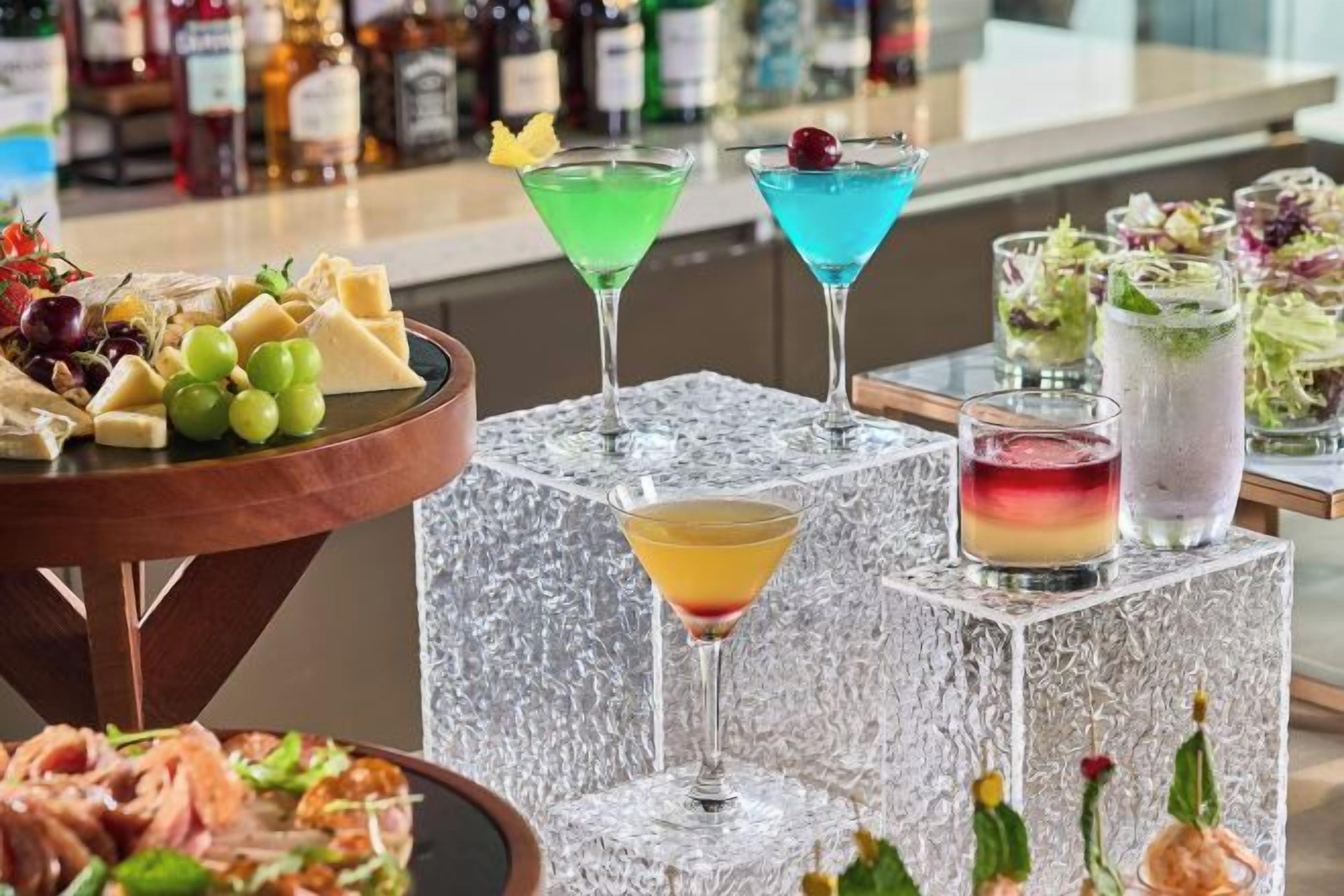 A bar area with various drinks and a selection of cheeses and fruits.