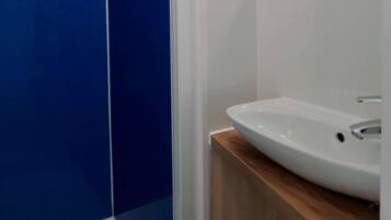 A bathroom with a blue wall, a white sink, and a mirror.