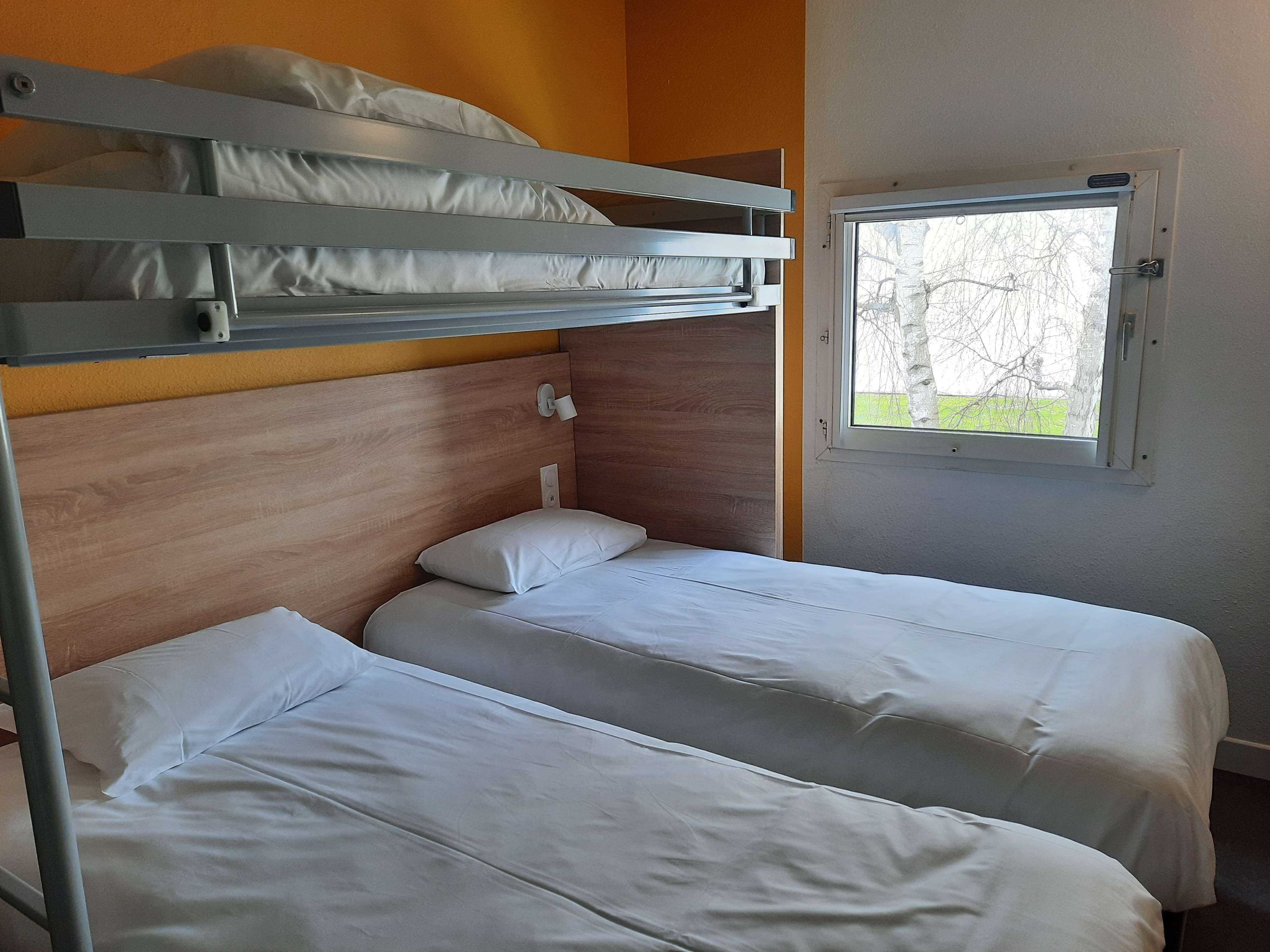 Camera con letto a castello e finestra vista alberi.