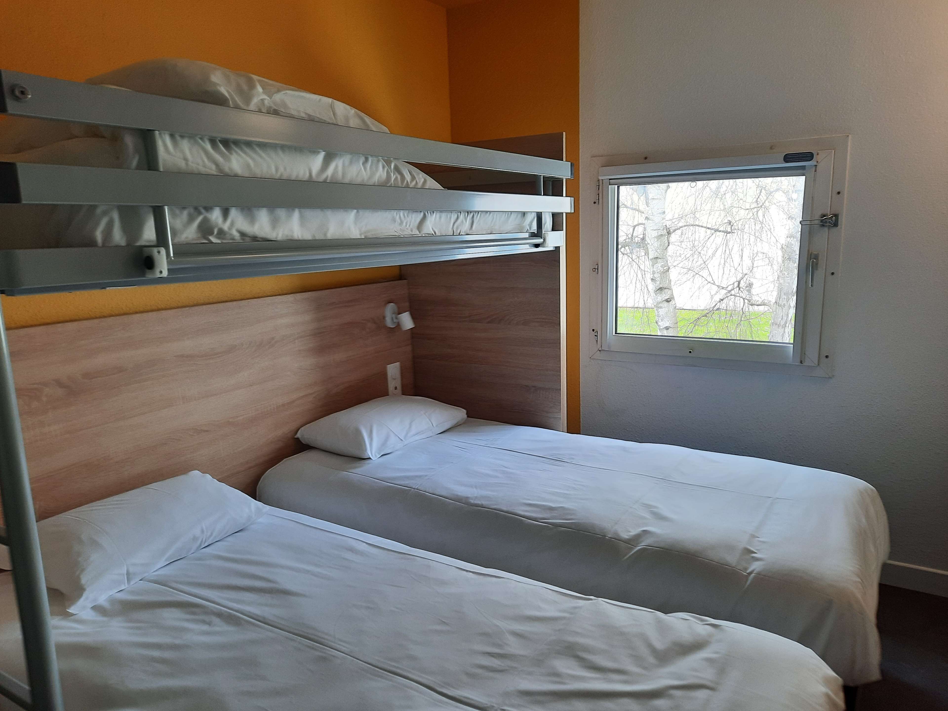 A bunk bed room with two single beds and a window.