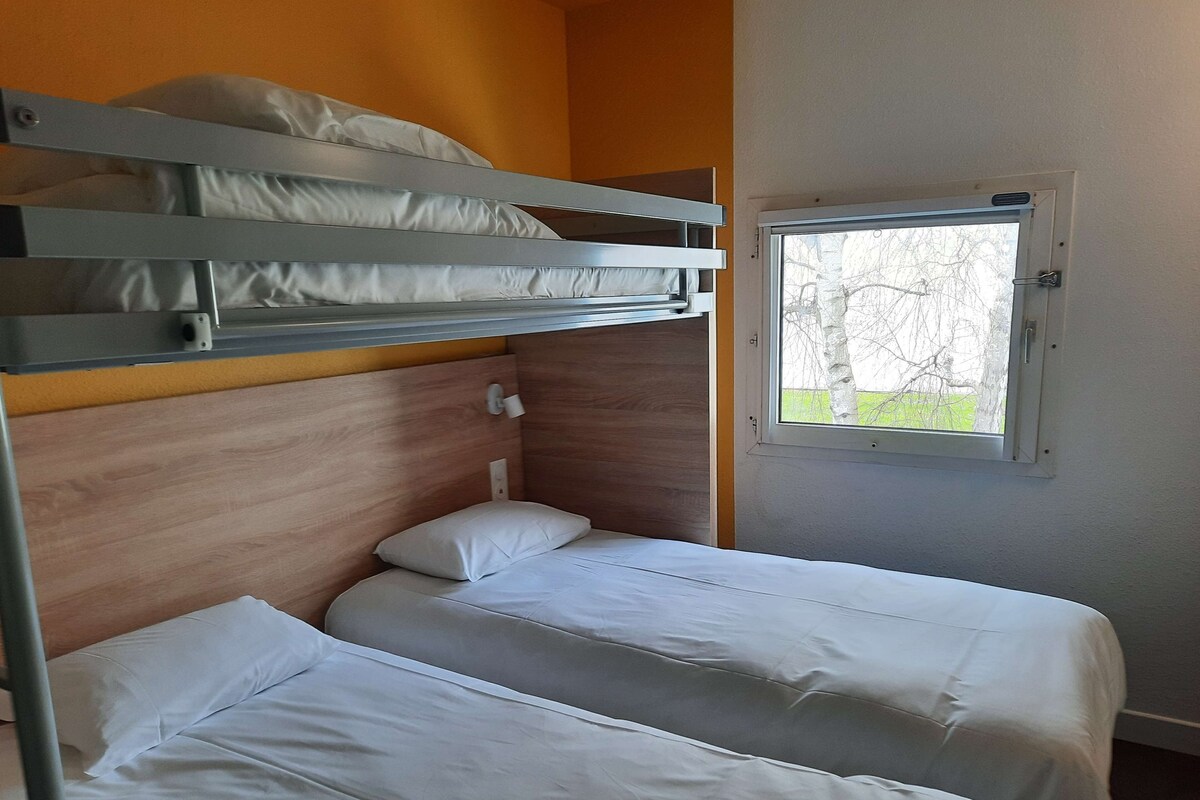 A bunk bed room with two single beds and a window.