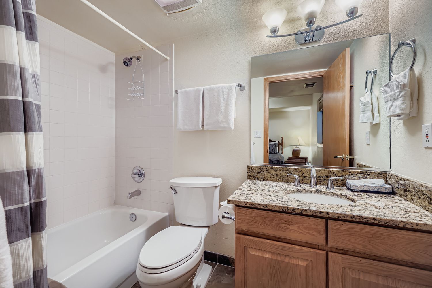 A bathroom with a bathtub, toilet, and sink.