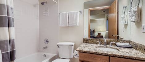 A bathroom with a bathtub, toilet, and sink.