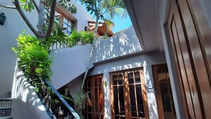 A courtyard with a staircase, potted plants, and a wooden door.