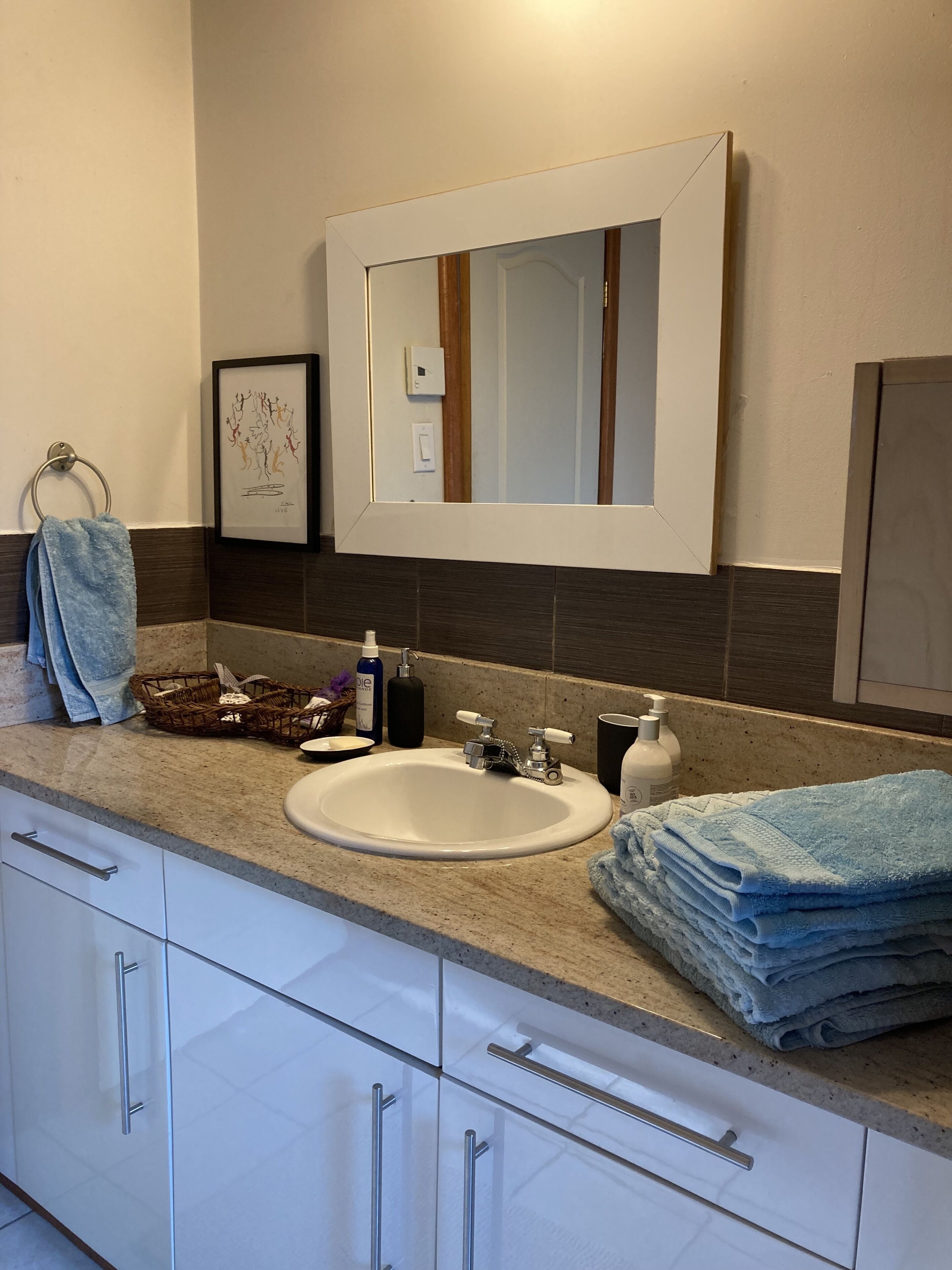 Ein Badezimmer mit Waschbecken, Spiegel und Handtuchhalter.