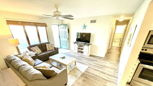 A living room with a sofa, coffee table, and TV stand.