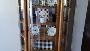 A glass-fronted wooden cabinet with multiple shelves, each holding decorative plates with phrases like "Blessed" and "Count your blessings." - Spacious 4 bedroom, 3 bath home with hot tub and mountain views.  (Luray)