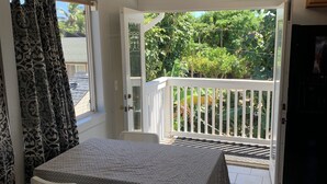 A dining area with a table and chairs, a view of the outdoors, and a ceiling light.
