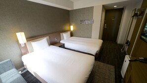 A hotel room with two beds, a desk, and a chair. - ibis Styles Tokyo Ginza (Tokyo)