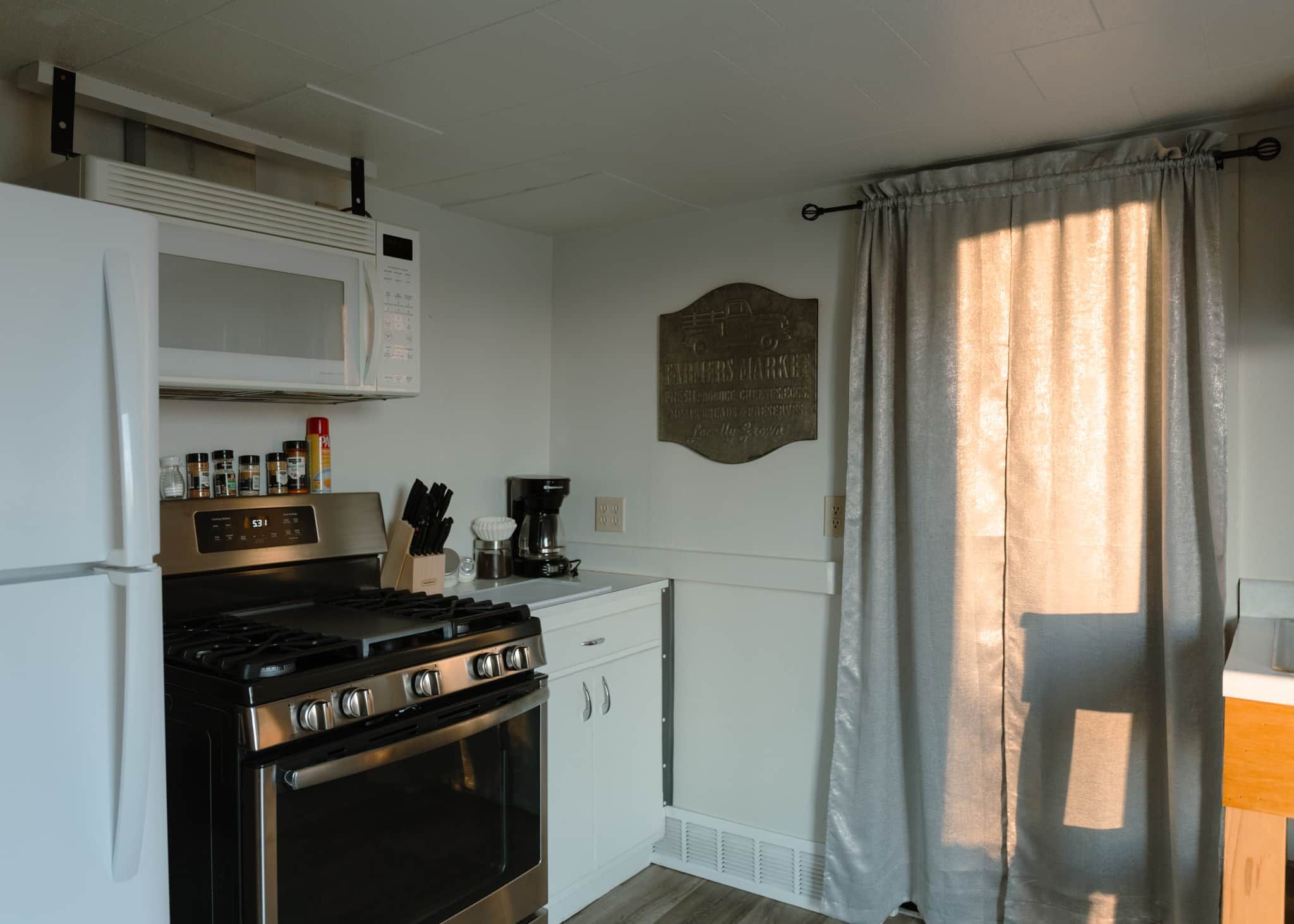 A compact kitchen with a stove, microwave, and cabinets.