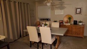 Un coin repas comprenant une table, des chaises et un buffet en bois.