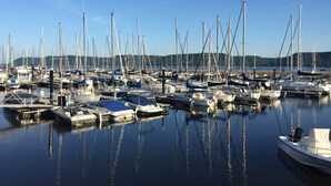 Een jachthaven met tal van boten afgemeerd, rustig water en een heldere lucht.