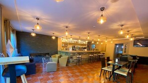 A restaurant with a bar area, seating, and a fireplace. - Somriu Vall Ski (Soldeu)