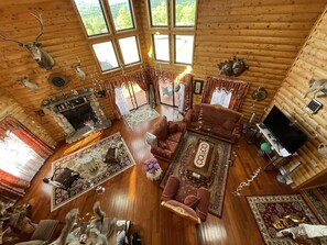 A log cabin interior with a fireplace, wooden floors, a sofa, and deer antlers on the walls. - My house is unique,  welcome EVERYONE to  enjoy beautiful VALLEY in Swane Lake.  (Swan Lake)