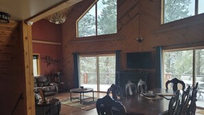 Una habitación amplia con una gran mesa de comedor, suelo de madera y una chimenea.