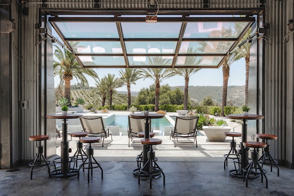 A patio with outdoor seating and a pool view.