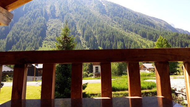 Ein hölzerner Balkon mit Blick auf einen bewaldeten Berg.