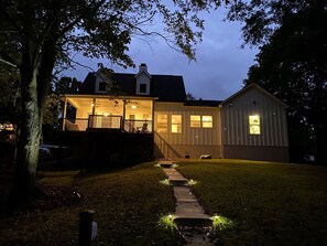 A house with a covered porch, a visible garage, and a pathway leading to the entrance. - Serenity Cove (Denver)